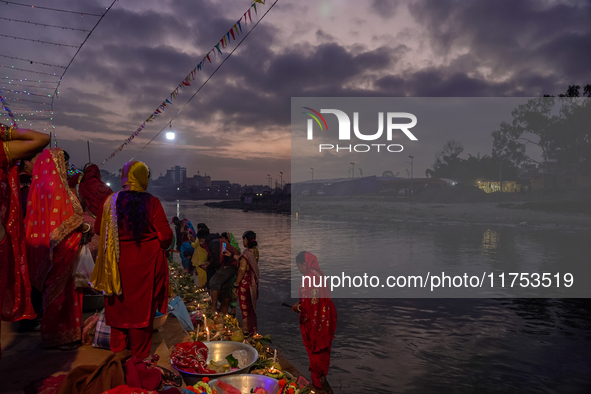 A Hindu devotee lights traditional oil lamps as she offers prayers to the sun during the Chhath Puja festival on the banks of the Bagmati Ri...