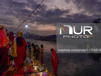 A Hindu devotee lights traditional oil lamps as she offers prayers to the sun during the Chhath Puja festival on the banks of the Bagmati Ri...