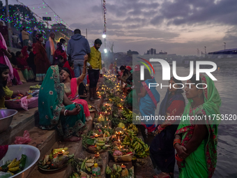 A Hindu devotee lights traditional oil lamps as she offers prayers to the sun during the Chhath Puja festival on the banks of the Bagmati Ri...