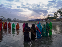 Hindu devotees perform rituals and offer prayers to the rising Sun God on the banks of the Bagmati River during the 'Chhath Puja' festival i...