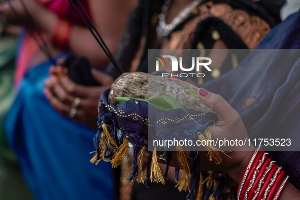 Hindu devotees perform rituals and offer prayers to the rising Sun God on the banks of the Bagmati River during the 'Chhath Puja' festival i...