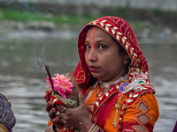 Hindu devotees perform rituals and offer prayers to the rising Sun God on the banks of the Bagmati River during the 'Chhath Puja' festival i...