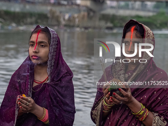 Hindu devotees perform rituals and offer prayers to the rising Sun God on the banks of the Bagmati River during the 'Chhath Puja' festival i...