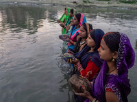 Hindu devotees perform rituals and offer prayers to the rising Sun God on the banks of the Bagmati River during the 'Chhath Puja' festival i...