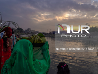 Hindu devotees perform rituals and offer prayers to the rising Sun God on the banks of the Bagmati River during the 'Chhath Puja' festival i...