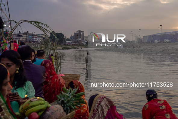 Hindu devotees perform rituals and offer prayers to the rising Sun God on the banks of the Bagmati River during the 'Chhath Puja' festival i...