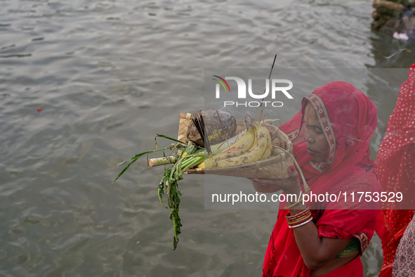 Hindu devotees perform rituals and offer prayers to the rising Sun God on the banks of the Bagmati River during the 'Chhath Puja' festival i...