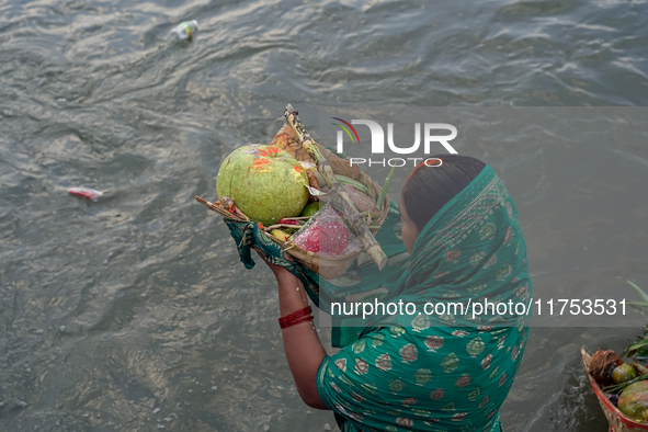 Hindu devotees perform rituals and offer prayers to the rising Sun God on the banks of the Bagmati River during the 'Chhath Puja' festival i...