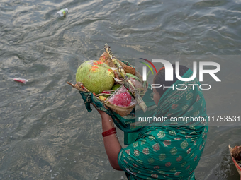 Hindu devotees perform rituals and offer prayers to the rising Sun God on the banks of the Bagmati River during the 'Chhath Puja' festival i...