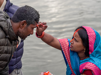 Hindu devotees apply tika after the rituals and offer prayers to the rising Sun God on the banks of the Bagmati River during the 'Chhath Puj...