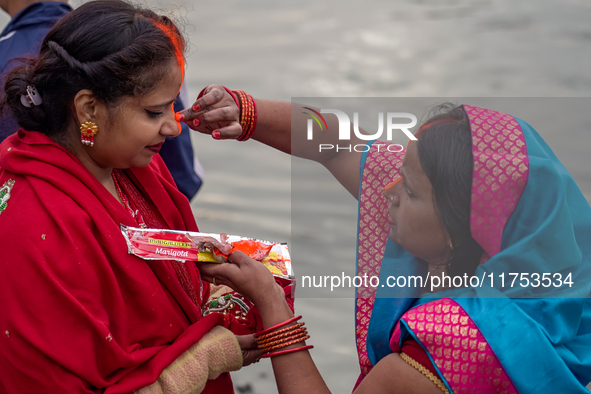 Hindu devotees apply tika after the rituals and offer prayers to the rising Sun God on the banks of the Bagmati River during the 'Chhath Puj...