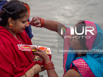 Hindu devotees apply tika after the rituals and offer prayers to the rising Sun God on the banks of the Bagmati River during the 'Chhath Puj...