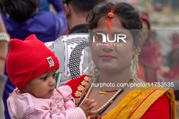 Hindu devotees perform rituals and offer prayers to the rising Sun God on the banks of the Bagmati River during the 'Chhath Puja' festival i...