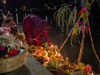 A Hindu devotee lights traditional oil lamps as she offers prayers to the sun during the Chhath Puja festival on the banks of the Bagmati Ri...