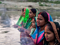 Hindu devotees perform rituals and offer prayers to the rising Sun God on the banks of the Bagmati River during the 'Chhath Puja' festival i...