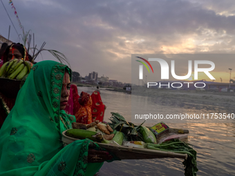 Hindu devotees perform rituals and offer prayers to the rising Sun God on the banks of the Bagmati River during the 'Chhath Puja' festival i...