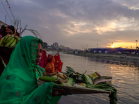 Hindu devotees perform rituals and offer prayers to the rising Sun God on the banks of the Bagmati River during the 'Chhath Puja' festival i...