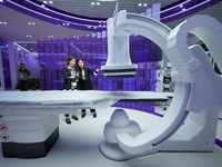 Visitors learn about integrated diagnosis and treatment equipment at the GE Medical booth of the 7th CIIE in Shanghai, China, on November 8,...