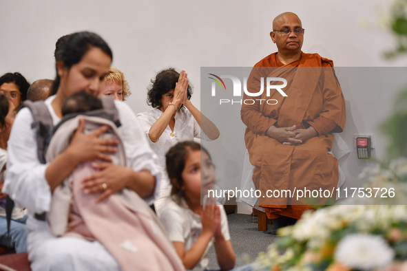 A Buddhist nun and devotees from the Sri Lankan Buddhist community offer prayers during a pirith chanting ceremony ahead of the annual Kathi...