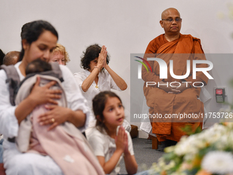 A Buddhist nun and devotees from the Sri Lankan Buddhist community offer prayers during a pirith chanting ceremony ahead of the annual Kathi...