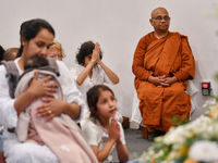 A Buddhist nun and devotees from the Sri Lankan Buddhist community offer prayers during a pirith chanting ceremony ahead of the annual Kathi...