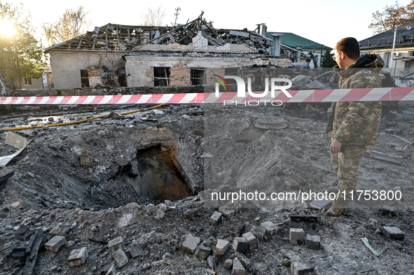 A man stands by the crater from a Russian guided bomb at an oncology dispensary in Zaporizhzhia, Ukraine, on November 7, 2024. Eight people,...