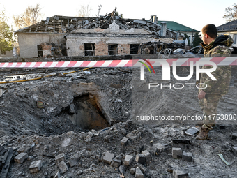 A man stands by the crater from a Russian guided bomb at an oncology dispensary in Zaporizhzhia, Ukraine, on November 7, 2024. Eight people,...