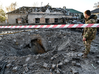 A man stands by the crater from a Russian guided bomb at an oncology dispensary in Zaporizhzhia, Ukraine, on November 7, 2024. Eight people,...