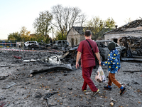 In Zaporizhzhia, Ukraine, on November 7, 2024, a doctor and a boy walk past a burnt-out car outside an oncology dispensary damaged by a Russ...