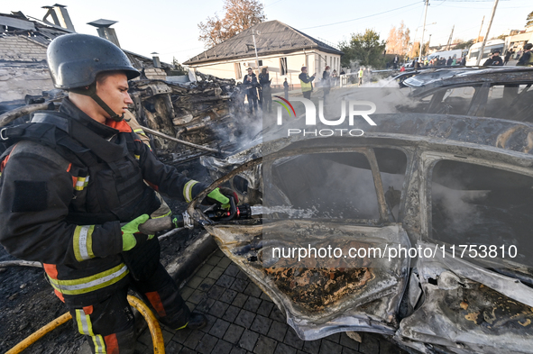 A firefighter extinguishes a fire in a car at an oncology dispensary damaged by a Russian guided bomb in Zaporizhzhia, Ukraine, on November...