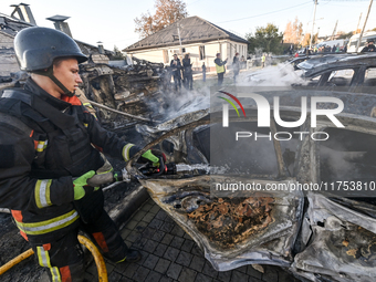 A firefighter extinguishes a fire in a car at an oncology dispensary damaged by a Russian guided bomb in Zaporizhzhia, Ukraine, on November...