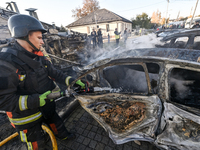 A firefighter extinguishes a fire in a car at an oncology dispensary damaged by a Russian guided bomb in Zaporizhzhia, Ukraine, on November...