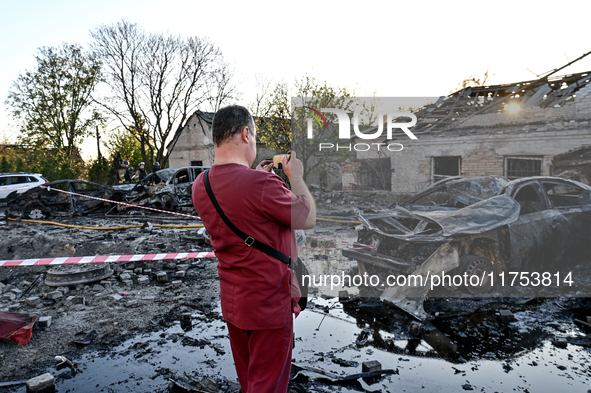 A doctor takes a picture of a burnt-out car outside an oncology dispensary damaged by a Russian guided bomb attack in Zaporizhzhia, Ukraine,...