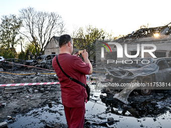 A doctor takes a picture of a burnt-out car outside an oncology dispensary damaged by a Russian guided bomb attack in Zaporizhzhia, Ukraine,...