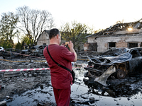 A doctor takes a picture of a burnt-out car outside an oncology dispensary damaged by a Russian guided bomb attack in Zaporizhzhia, Ukraine,...