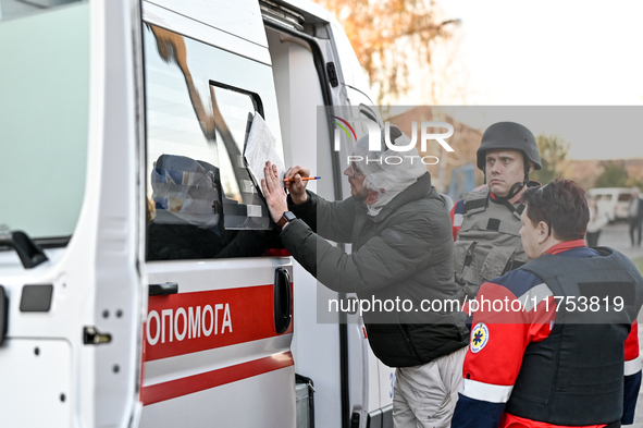 An injured man signs papers by an ambulance after a Russian guided bomb in Zaporizhzhia, Ukraine, on November 7, 2024. Eight people, includi...