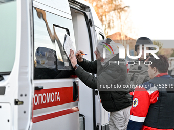 An injured man signs papers by an ambulance after a Russian guided bomb in Zaporizhzhia, Ukraine, on November 7, 2024. Eight people, includi...