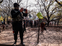 An Indian soldier takes pictures of the house that is damaged during an encounter in which two militants are killed in Sopore, Jammu and Kas...