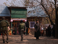 Indian soldiers and villagers look towards the house that is damaged during an encounter in which two militants are killed in Sopore, Jammu...