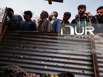 Indian soldiers and villagers look towards the house that is damaged during an encounter in which two militants are killed in Sopore, Jammu...