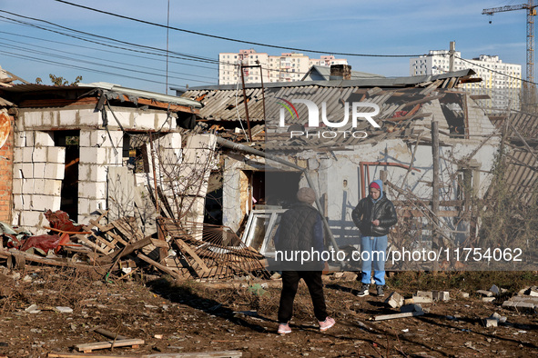 People stand among the debris of a damaged building after an overnight Russian drone attack in Odesa, Ukraine, on November 8, 2024. One pers...