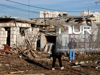 People stand among the debris of a damaged building after an overnight Russian drone attack in Odesa, Ukraine, on November 8, 2024. One pers...