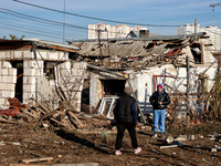 People stand among the debris of a damaged building after an overnight Russian drone attack in Odesa, Ukraine, on November 8, 2024. One pers...