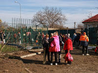 People stand outside a building housing both a school and kindergarten, which is damaged by a shock wave during an overnight Russian drone a...