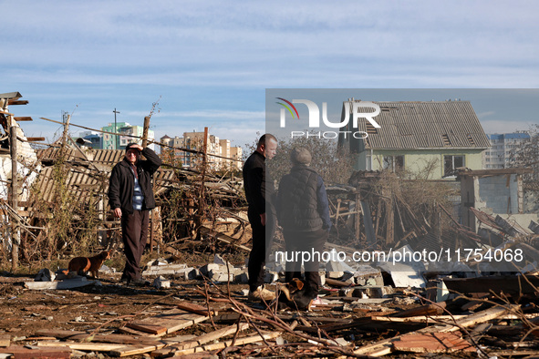 People stand among the debris of a damaged building after an overnight Russian drone attack in Odesa, Ukraine, on November 8, 2024. One pers...