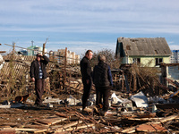 People stand among the debris of a damaged building after an overnight Russian drone attack in Odesa, Ukraine, on November 8, 2024. One pers...