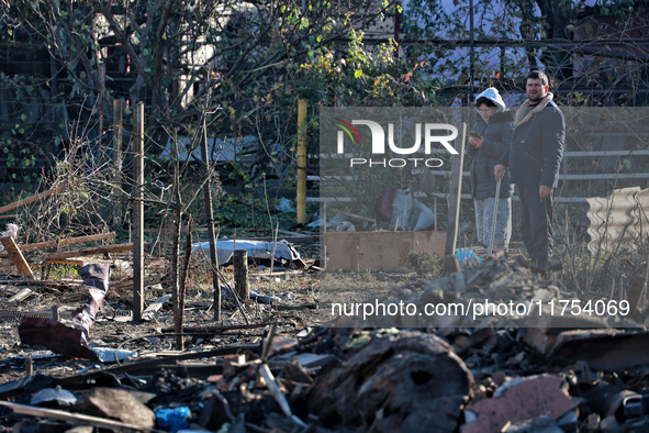 People stand among the debris of a damaged building after an overnight Russian drone attack in Odesa, Ukraine, on November 8, 2024. One pers...