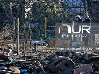 People stand among the debris of a damaged building after an overnight Russian drone attack in Odesa, Ukraine, on November 8, 2024. One pers...