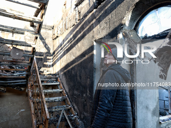 A man looks at a staircase in a house that burns down as a result of an overnight Russian drone attack in Odesa, Ukraine, on November 8, 202...