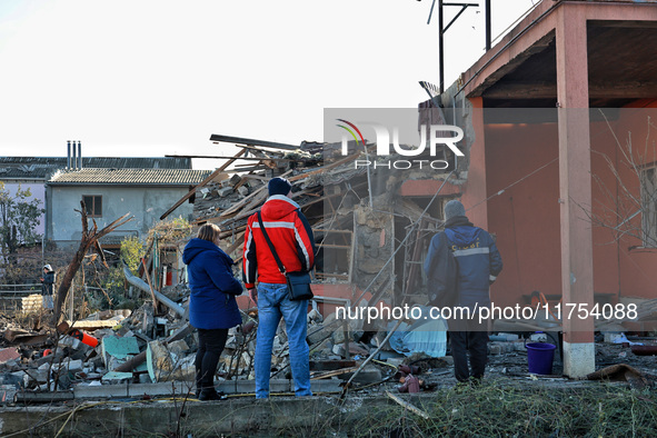 People stand among the debris of a damaged building after an overnight Russian drone attack in Odesa, Ukraine, on November 8, 2024. One pers...